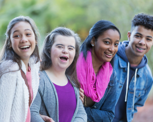 Inclusive communication between four young people standing outdoors smiling