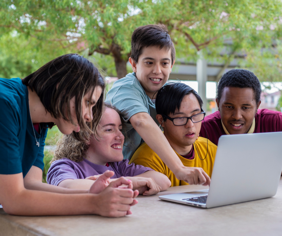 Young people with disabilities look at a computer screen and give user testing and feedback on a computer.